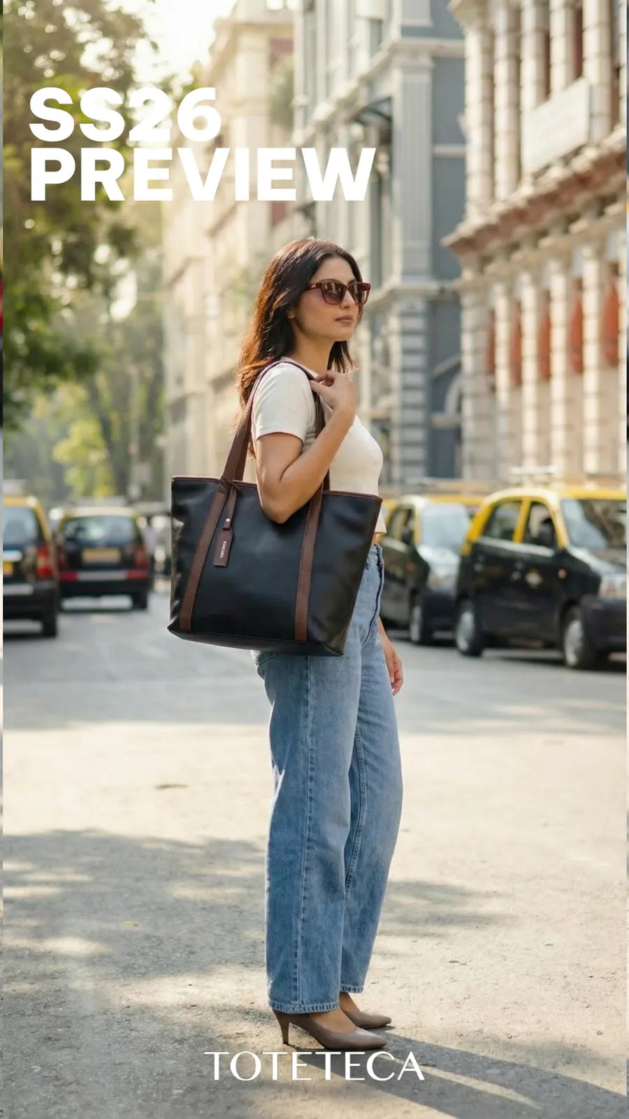 Toteteca SS26 - model crossing a heritage street with a navy tote