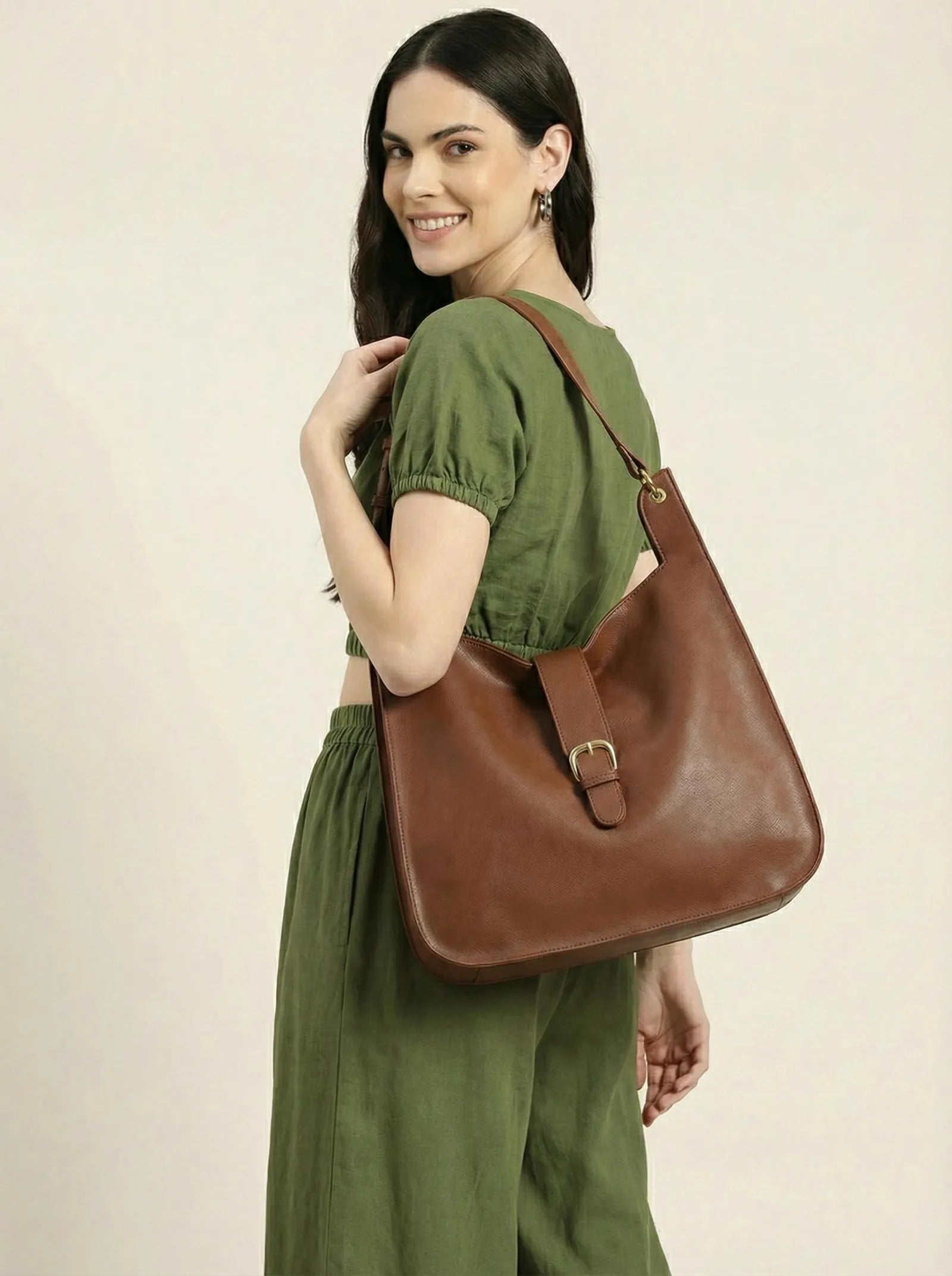 Model in an olive co-ord with a brown Toteteca hobo on her shoulder