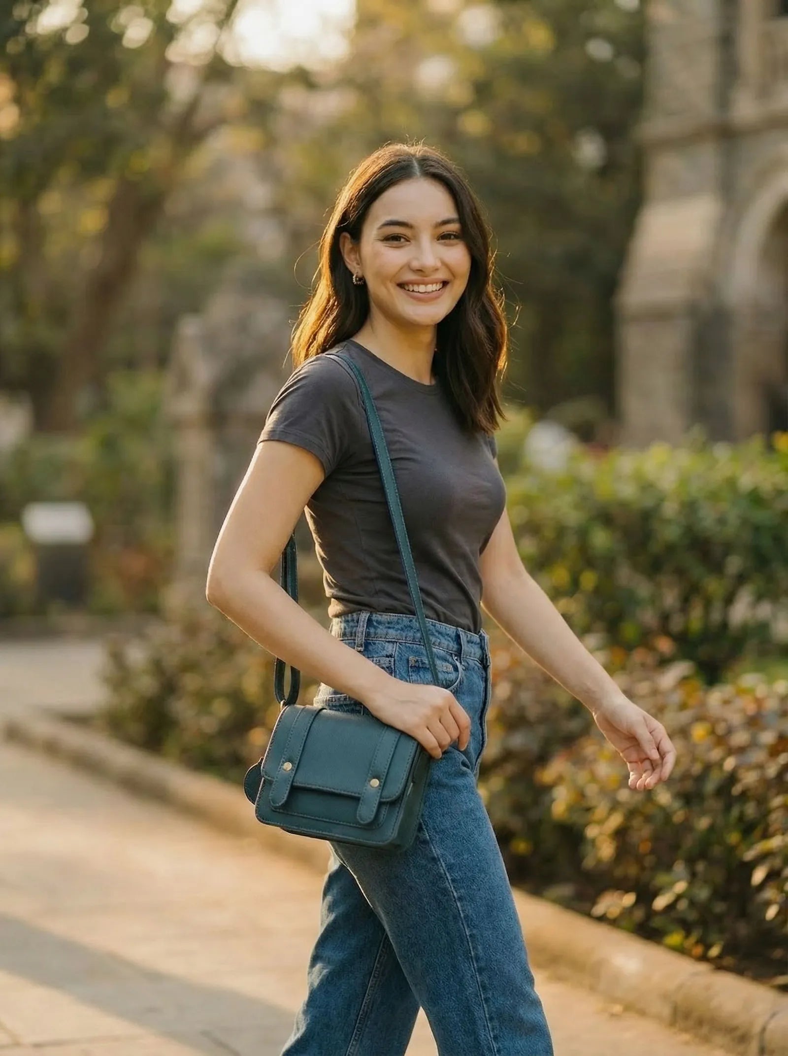 Woman in a grey tee wearing a teal Toteteca satchel crossbody outdoors