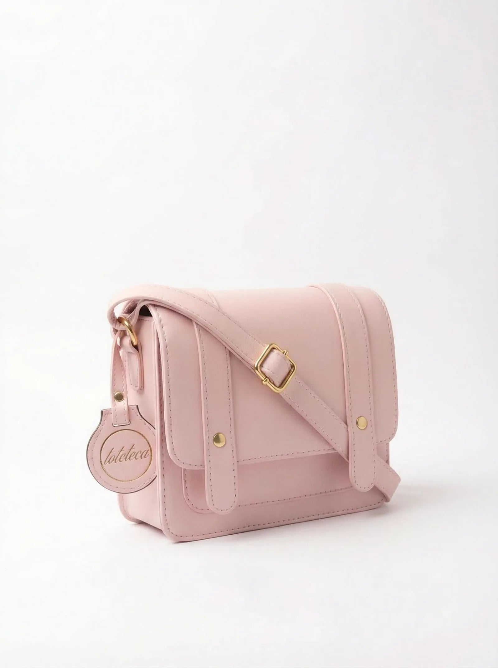 Blush pink Toteteca satchel with gold buckles and crossbody strap