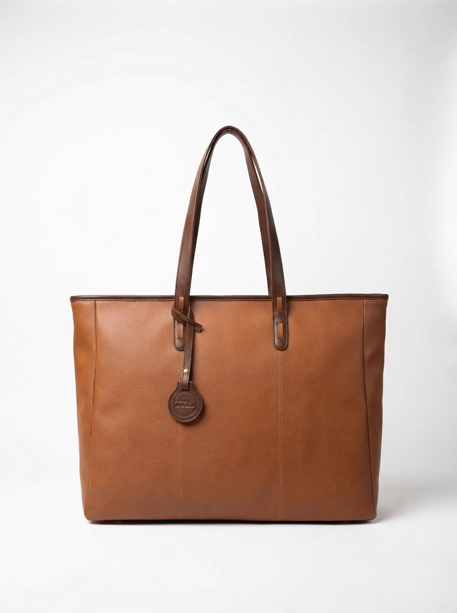 Tan Toteteca tote with dark brown trim and charm