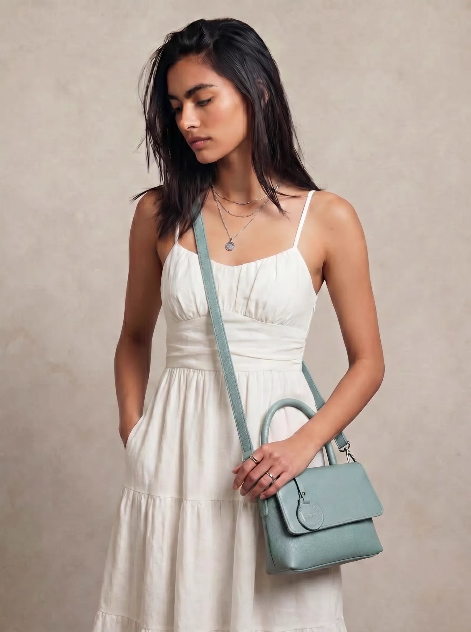 Mint green Toteteca crossbody bag worn with a white summer dress