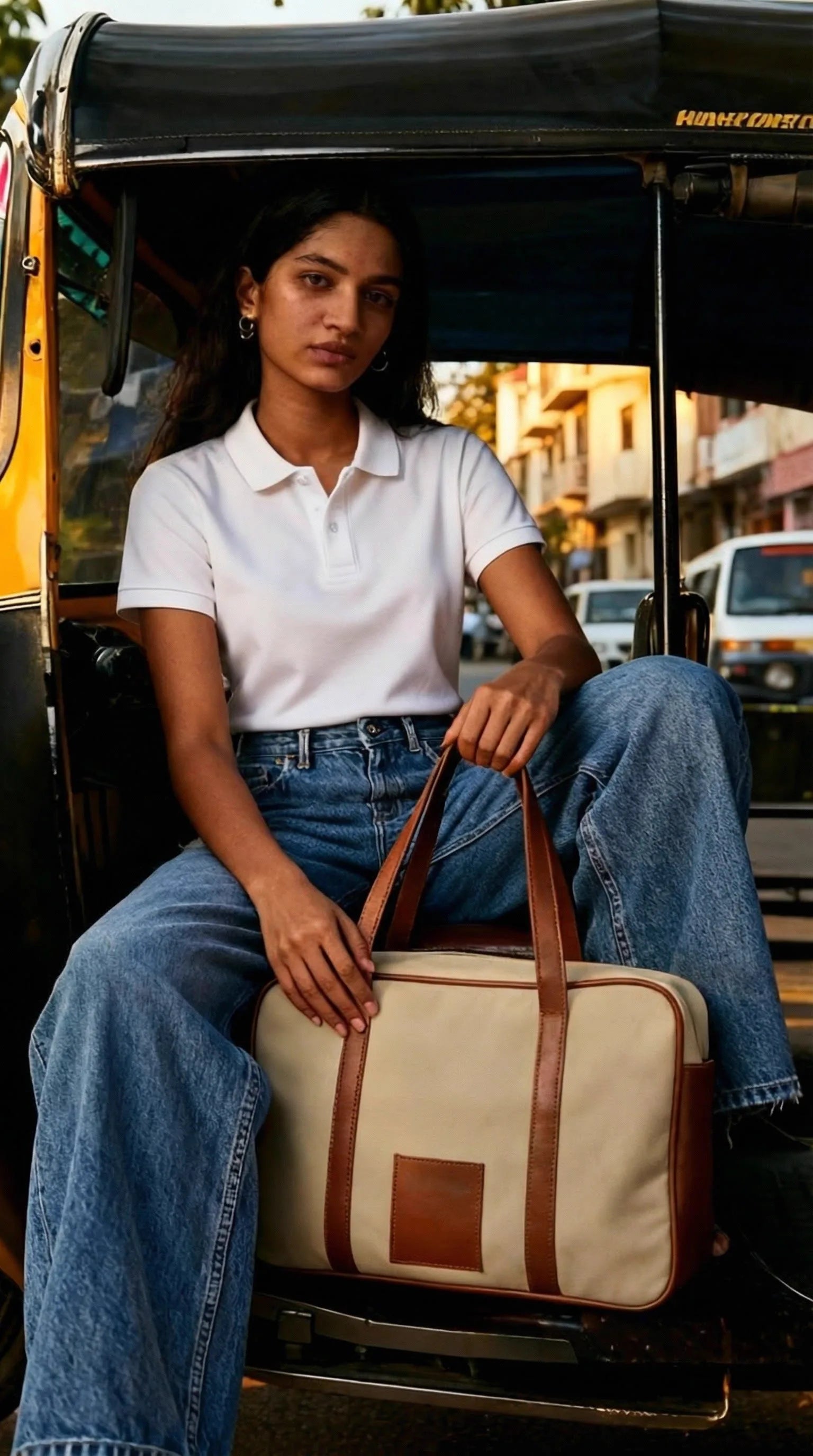 Woman seated in a Mumbai auto-rickshaw with a cream and tan Toteteca duffel bag