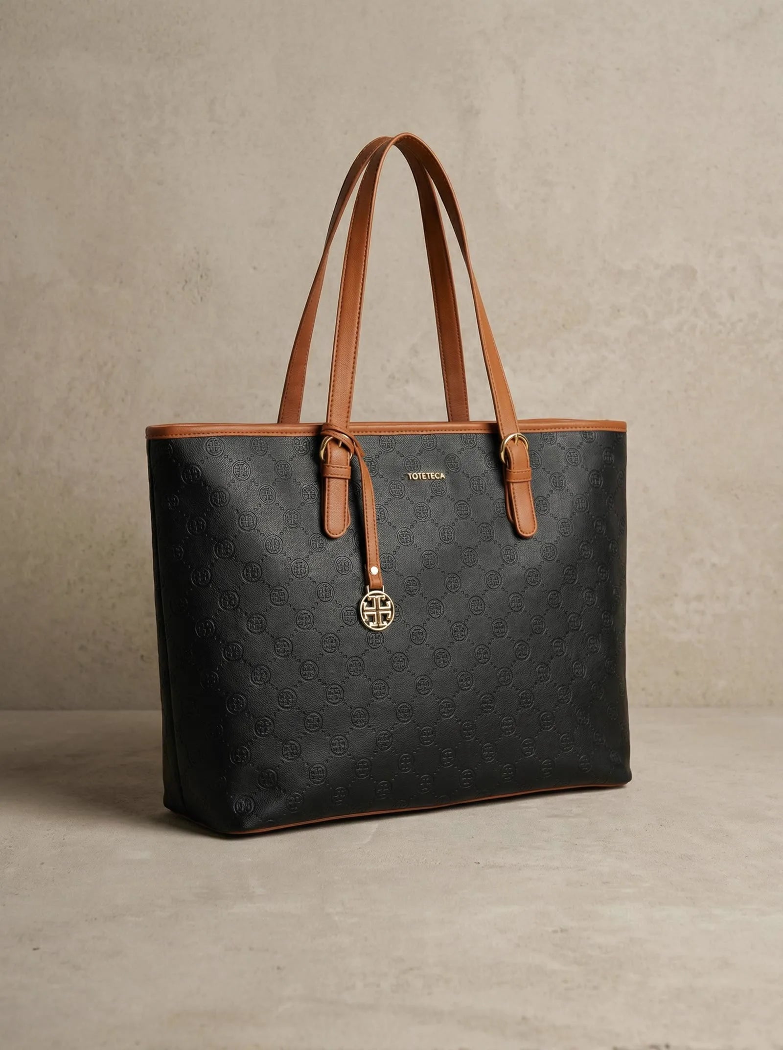 Black monogram-embossed Toteteca tote with tan handles